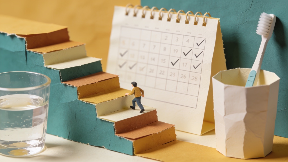 Mão marcando um calendário de parede ao lado de uma xícara e de um copo de água